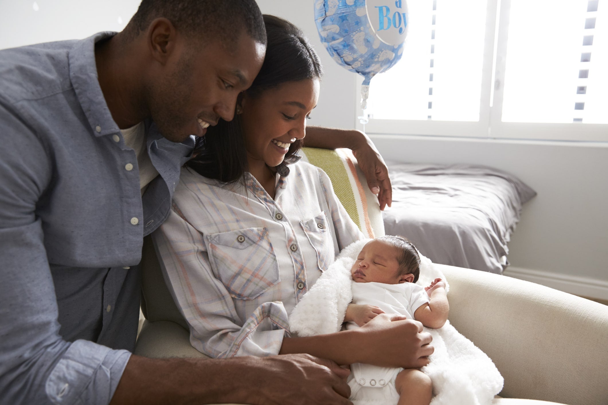 Happy new parents holding baby.