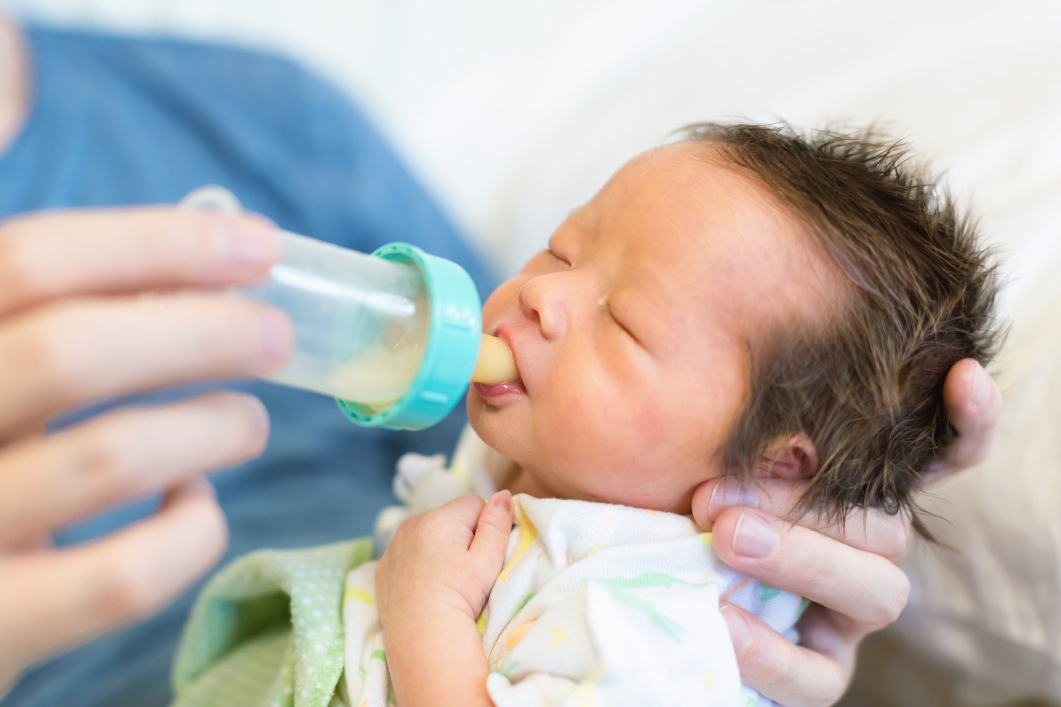 Father feeding newborn.
