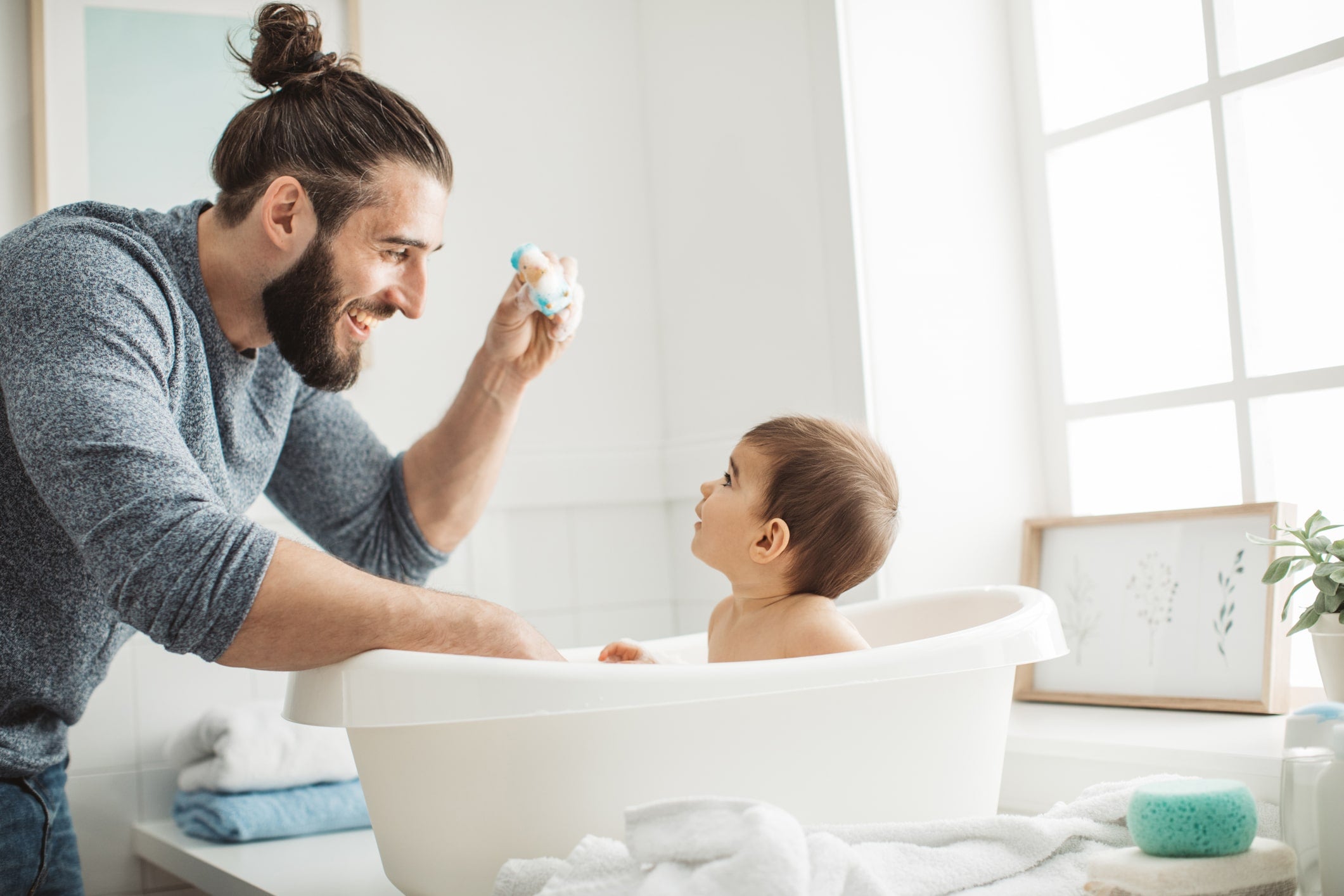 Happy father giving his baby a bath.
