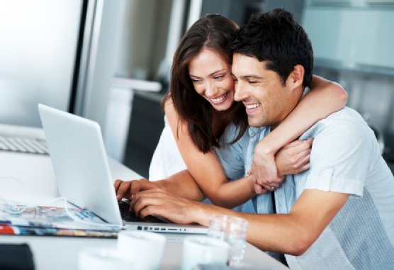 Smiling, young couple surfing the internet on a laptop